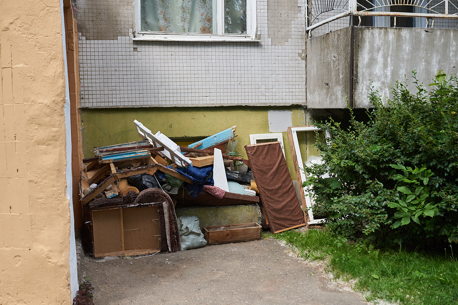 A large pile of rubbish under the Windows of a house for any purpose